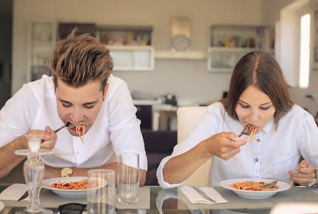 Par jovem, comendo macarrão