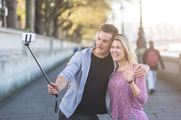 Par jovem, levando, um, selfie, com, smartphone, ligado, a, vara