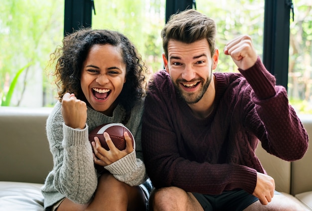 Par jovem, observar, futebol americano, casa