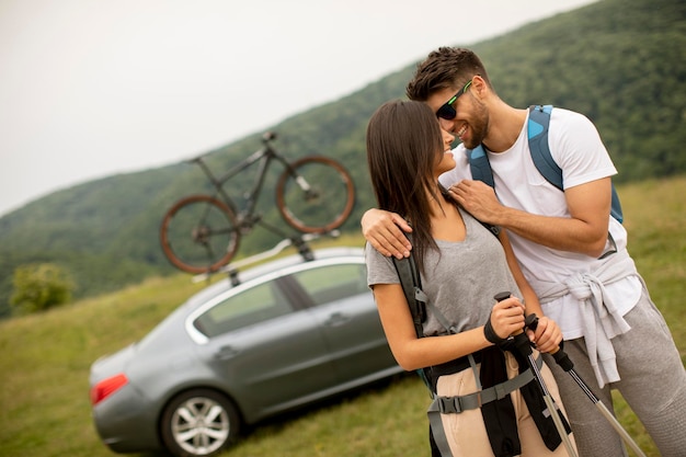 Un par de jóvenes excursionistas con mochilas comenzando un paseo por los campos