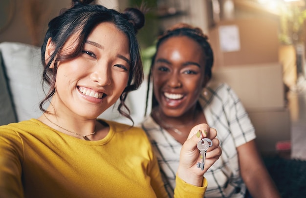 Un par de llaves de amigos y una nueva selfie de casa para mudarse juntos para una inversión inmobiliaria Alquiler de hipotecas y préstamos de mujeres con una sonrisa para un retrato en las redes sociales en un apartamento o casa con su pareja