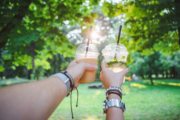 Un par de manos sosteniendo una taza con una bebida refrescante