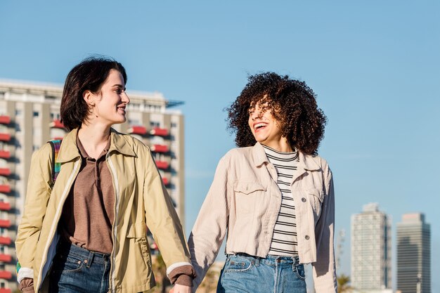 Par de mujeres charlando y caminando en la ciudad.