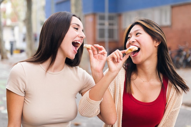 Un par de mujeres jóvenes compartiendo unos bollos dulces