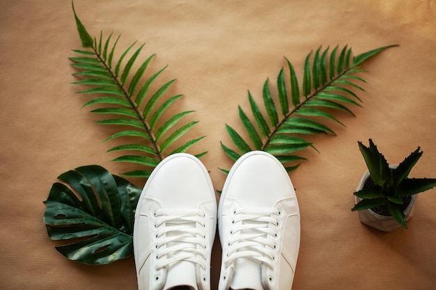 Foto par de nuevas zapatillas blancas con estilo en el piso de madera.