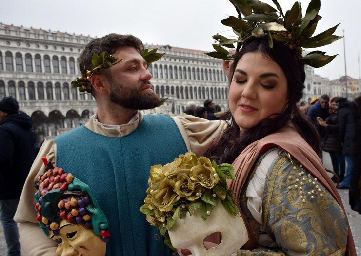 Un par de personas disfrazadas para el Carnaval de Venecia con trajes de Baco y Ariadna