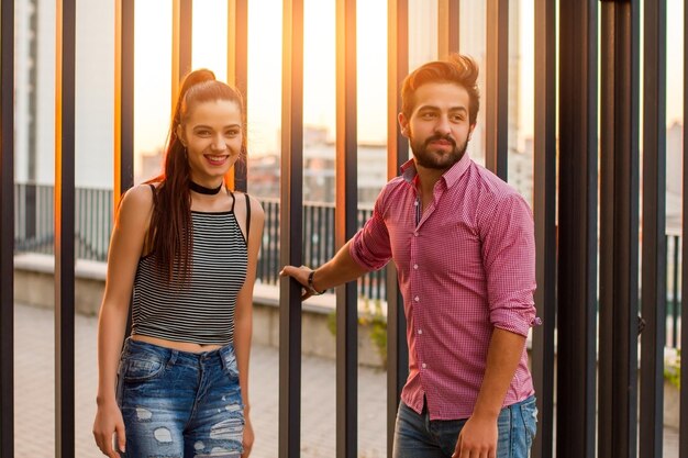 Par de pie sobre fondo urbano sonriente mujer joven juventud y relaciones