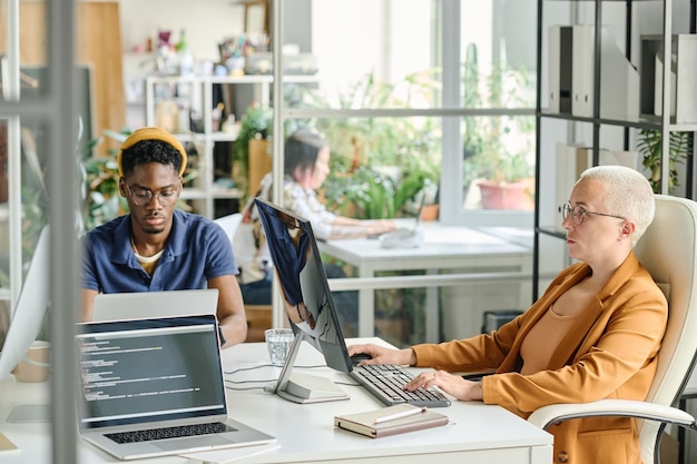 Un par de programadores trabajando en computadoras en la mesa