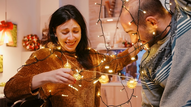 Par reír y enredarse en una cadena de luces navideñas