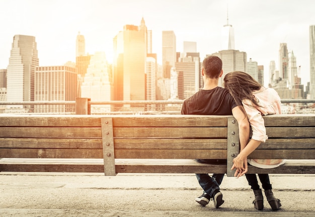 Par relajarse en el banco de Nueva York frente al horizonte al atardecer. concepto sobre amor, relación y viaje