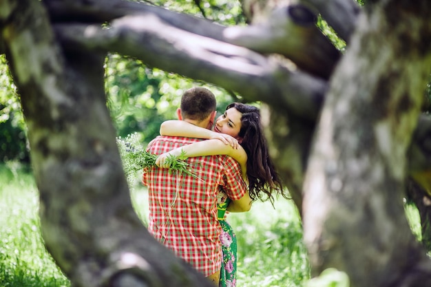 Foto par relajarse en el jardín verde. una pareja encantadora camina en un prado verde.