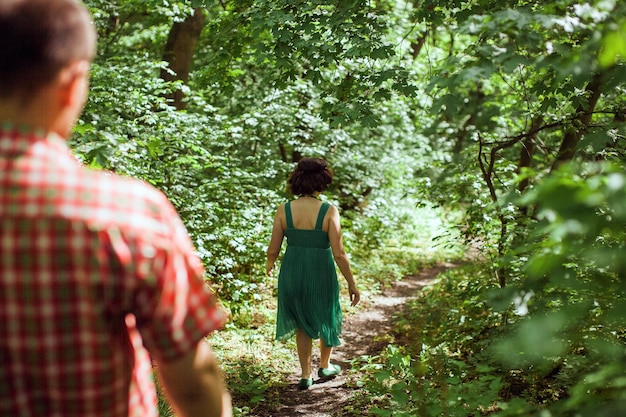 Par relajarse en el jardín verde. Una pareja encantadora camina en un prado verde.