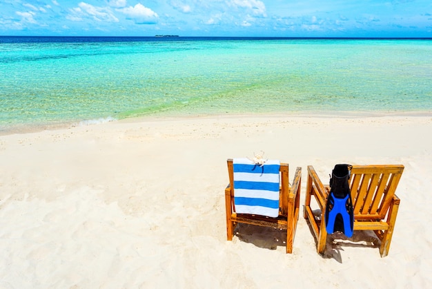 Par de silla de madera de pie en una playa del Océano Índico