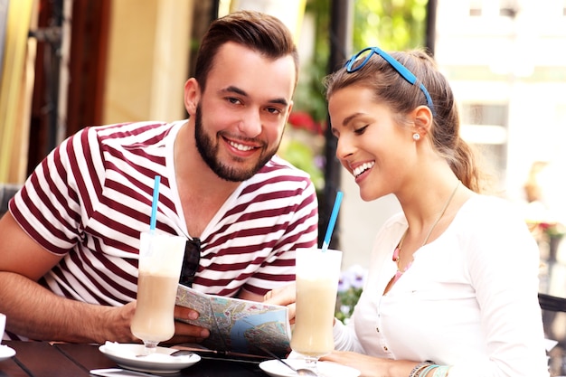 Par de turistas bebiendo frappé en un café