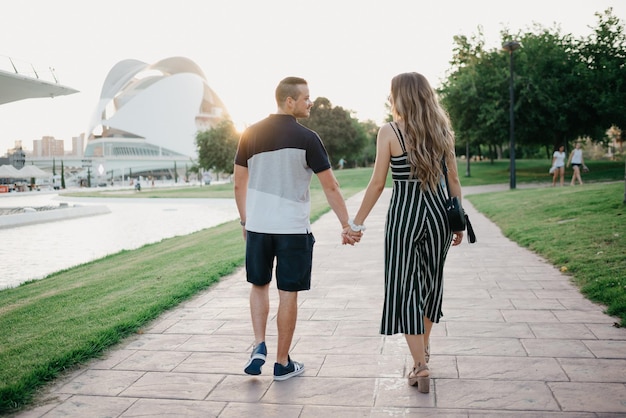 Un par de turistas caminan en el espacio urbano moderno al atardecer en Valencia