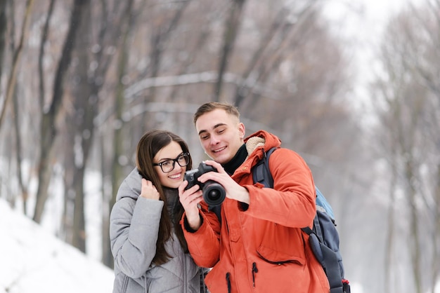 Un par de turistas de pie y mirando la foto a la cámara mientras caminan por el bosque