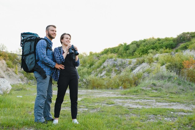 Un par de turistas en tiempo de viaje de acero y admirar el hermoso paisaje de montaña