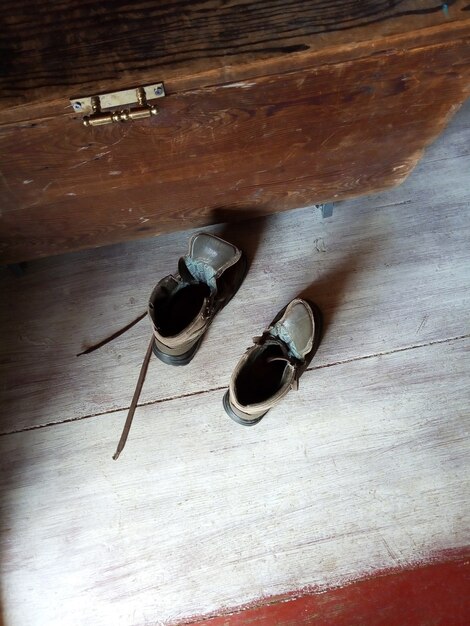 Foto par de viejos zapatos marrones sobre piso de madera caja retro de zapatos junto a ellos vista superior luz natural