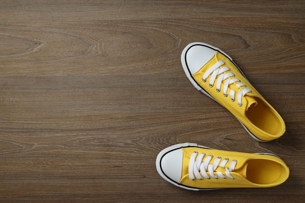 Foto par de zapatillas amarillas sobre fondo de madera