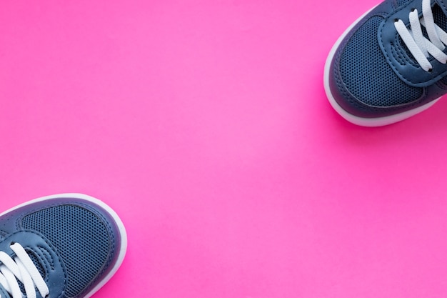 Par de zapatillas azules nuevas aisladas sobre fondo rosa