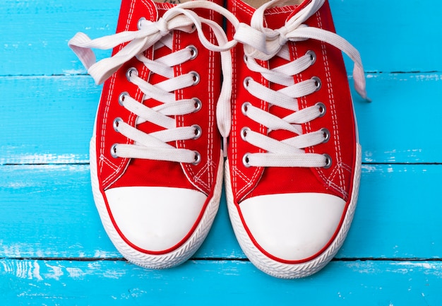 Par de zapatillas deportivas rojas con cordones blancos.