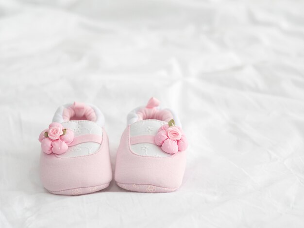 Foto un par de zapatos de bebé rosa en manta con espacio de copia