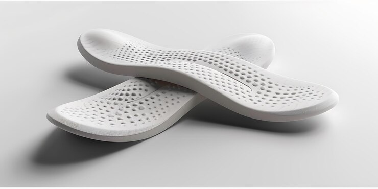un par de zapatos blancos con agujeros en ellos en una superficie gris
