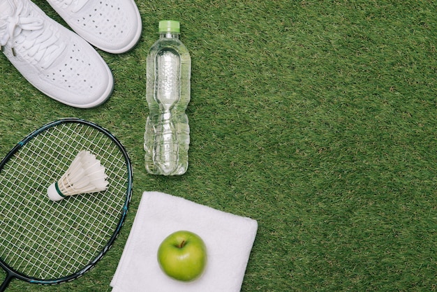 Par de zapatos deportivos, manzana fresca y accesorios para el deporte en la hierba verde, estilos de vida saludables y activos, espacio para copiar texto o inscripción