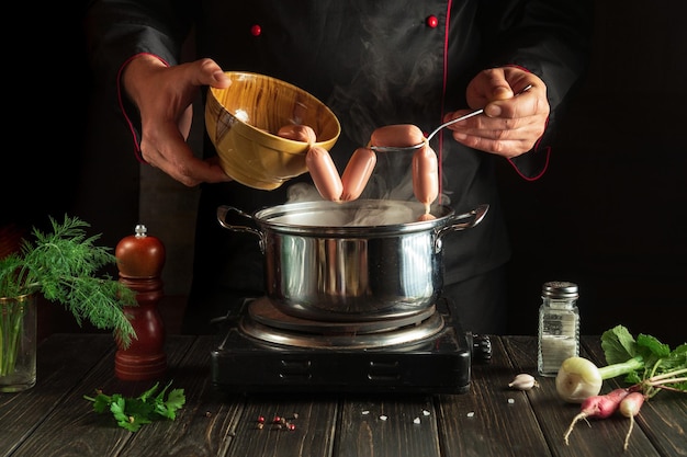 Para o jantar, você precisa cozinhar deliciosas salsichas de carne em uma panela Chef na cozinha no trabalho Ideia de menu para um hotel ou restaurante