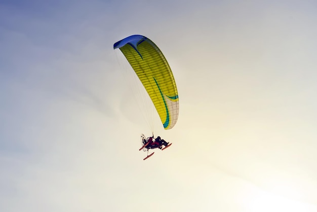 Pára-quedas motorizado contra o céu azul. Esportes extremos. Parapente. Planador a motor. paraleta