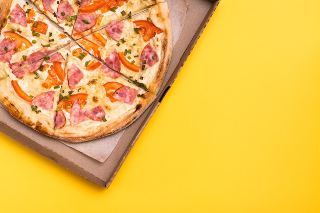 Para viagem e entrega. Pizza pronta em caixa de papelão com fundo amarelo