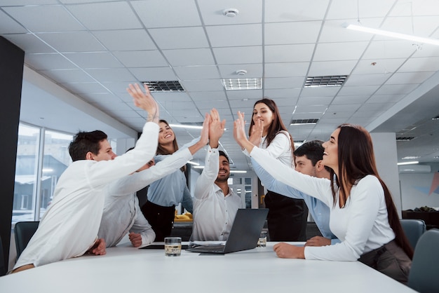 Parabenizando um ao outro. O trabalho está feito. Grupo de trabalhadores de escritório felizes em bater seus próprios recordes e ter sucesso