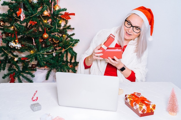 Parabéns pela família online de natal. menina sorridente em casa usando laptop