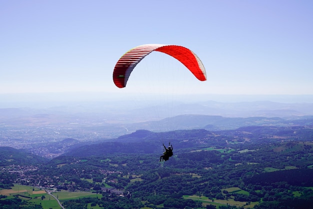 Paracaídas parapente en el cielo Puy de Dôme cielo azul en el macizo francés Francia Central