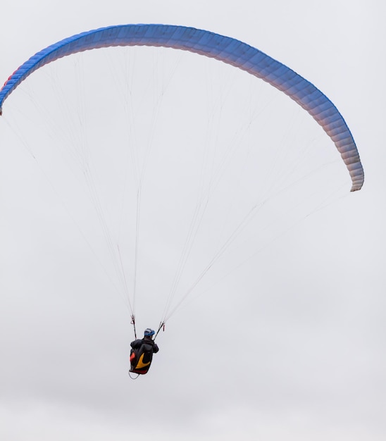 Foto paracaidista de deportes extremos de paracaidismo con un paracaídas desplegado el deportista volando en un parapente