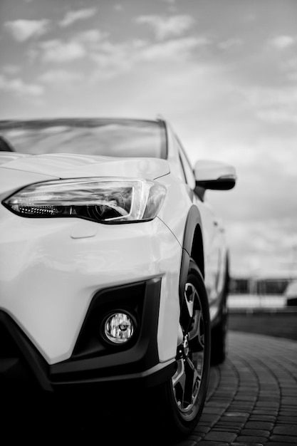 Foto parachoques, delantero del automóvil deportivo blanco. el automóvil está en la carretera. elemento de diseño. el faro del nuevo automóvil deportivo blanco limpio. imagen en blanco y negro