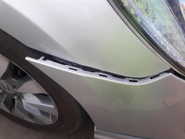 El parachoques delantero dañado de un coche plateado