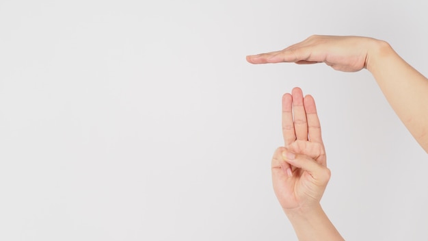 Parada de segurança por Segure uma mão espalmada sobre o sinal de mão de três dedos levantados isolado no fundo branco.