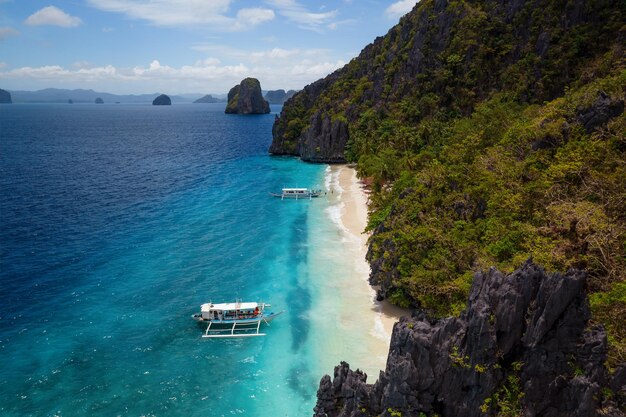 Foto paradiesischer strand mit türkisfarbenem wasser und ein paar, das sich alleine auf einer insel auf den philippinen vergnügt