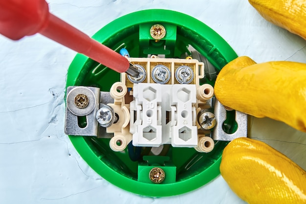 Parafuso de torção no novo botão com ajuda de chave de fenda, manutenção elétrica.