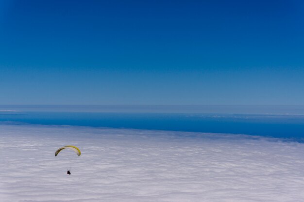 Paragliding über einem Wolkenmeer am Himmel an einem klaren sonnigen Tag