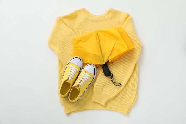 Un paraguas amarillo con una blusa y zapatillas.