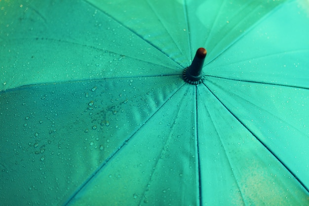 Paraguas azul con gotas de lluvia. Concepto de clima de otoño