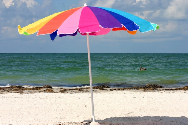 Foto paraguas colorido en la playa en un día soleado