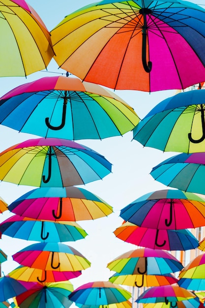 Paraguas coloridos pendurados na rua da cidade isolados no céu azul cores do orgulho lgtbi