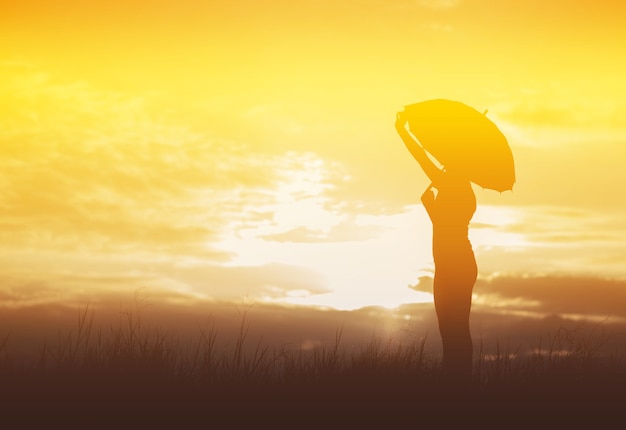 Paraguas mujer y silueta al atardecer