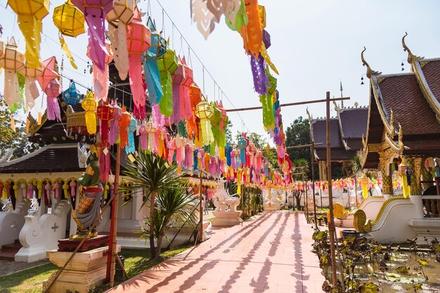 Paraguas multicolores colgando fuera del templo contra el cielo en la ciudad
