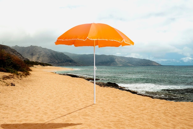 Paraguas naranja en la playa