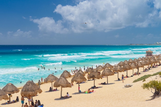 Paraguas en una playa de arena con agua azul en un día soleado cerca de Cancún México