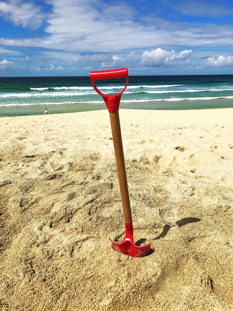 Paraguas rojo en la playa contra el cielo